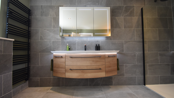 Pelipal Cassca vanity unit in Riviera Oak Horizontal effect with Mineral Marble Wash Basin Matt Black Handle and  shadow gap LED Lighting