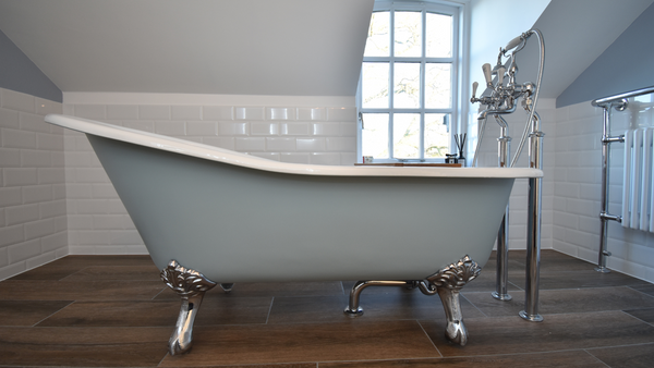 Beaulieu cast iron bath in cornflower blue with claw chrome feet against bevelled brick tiles in white and liberty mocha porcelain floor tiles