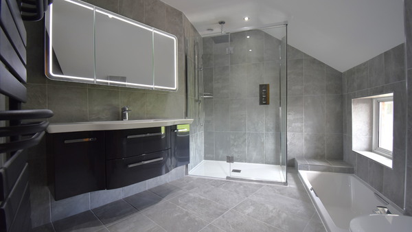 Pelipal unit, shower cubicle, sunken bath and wall hung pan with grey tiled walls and floor