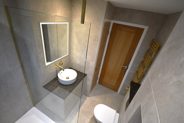 A bathroom showing a basin, shower unit, towel rail, and toilet, all fitted by The Bathroom Sanctuary.