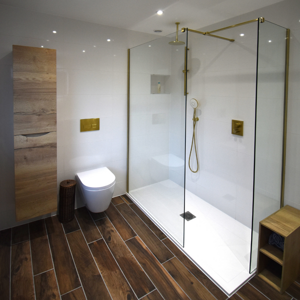 Crosswater walk-in shower in brushed brass with cilantro wall hung WC and Windsor oak tall storage unit