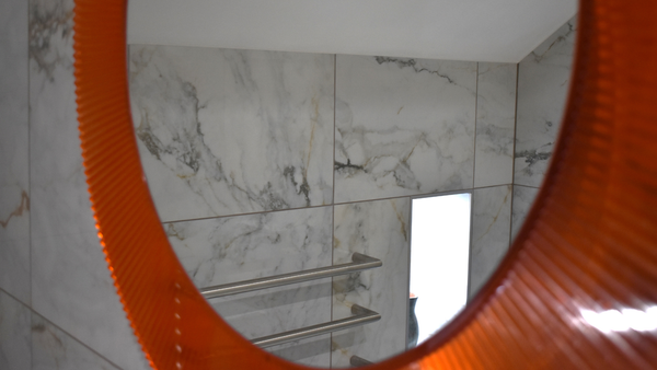 View of tiled wall and niche from mirror