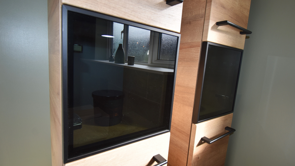 Pelipal Pcon wall hung storage units with black smoked glass doors and matt black handles