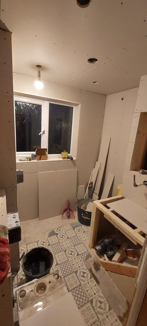 Floor tiles and plaster board being fitted during a bathroom fitting by The Bathroom Sanctuary.